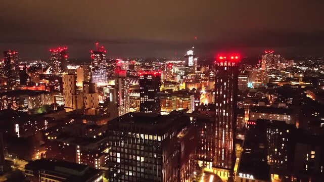 Manchester UK: 16th August 2026: A drone view of the Manchester skyline near Central shows buildings illuminated by city lights at night