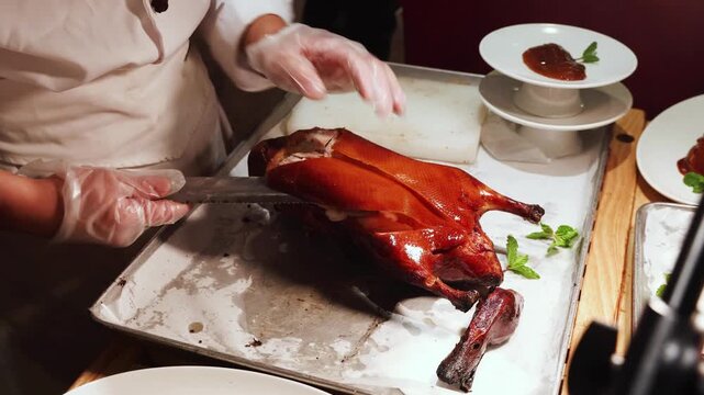 Chef cutting serving popular Peking Duck or Beijing duck, crispy skin roasted to perfection in restaurant China