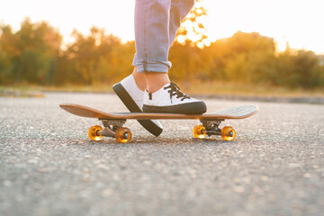 Girl standing on a skateboard. Close up of feet and skateboard. © alones