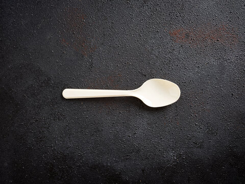 Disposable compostable spoon on dark background