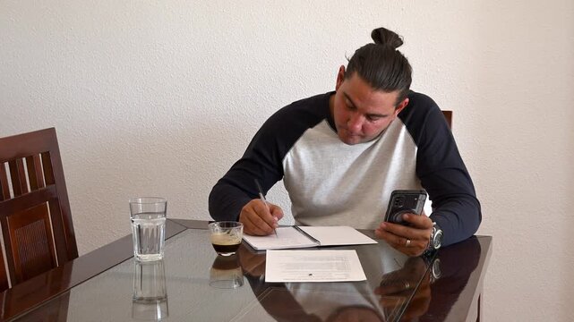 Stressed man signing documents at home office