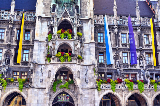 Close Up View of New Town Hall Facade with Colorful Flowers and Flags at Marienplatz in Munich Germany