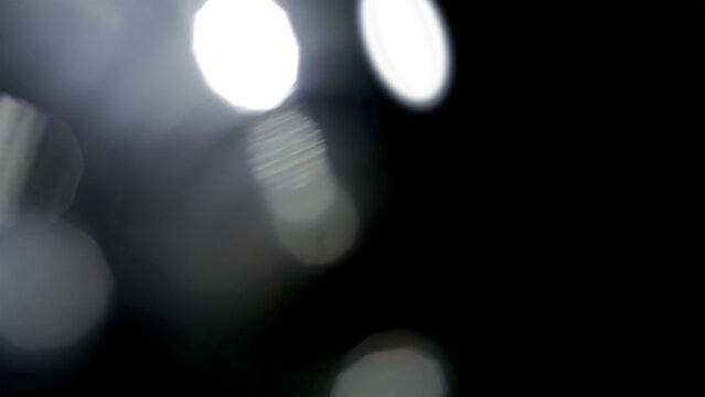 Abstract white bokeh light orbs on a deep black background