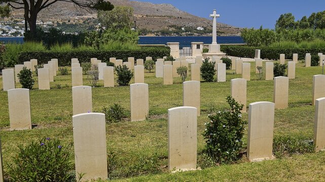 Cemetery with many gravestones in front of mountains and sea under blue sky, Military Cemetery, Commonwealth War Cemetery, WW2, 1939-1945, 179 graves, Alinda, Leros, Dodecanese, Greek Islands, Greece