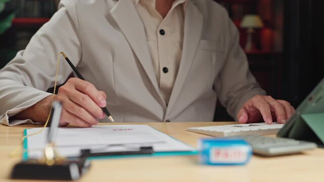 Accountant processes invoice payment, confirming bill payment status after checking invoice ledger document.