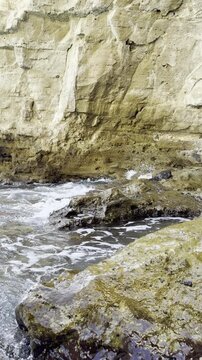 Small Mediterranean wave washing over a coastal rock on Ischia Island, Italy
