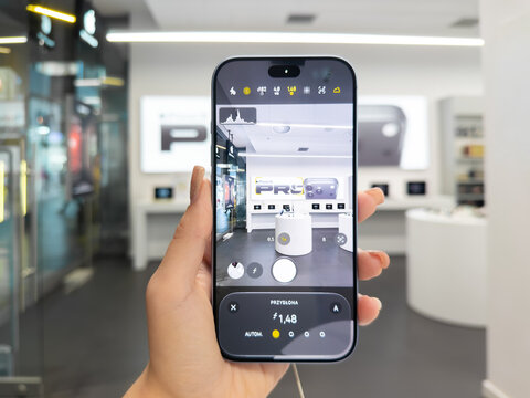 Poznan, Poland - September 19, 2026: An iPhone 18 Pro used for photography within a modern retail showroom, where the screen shows precise camera settings and a live viewfinder