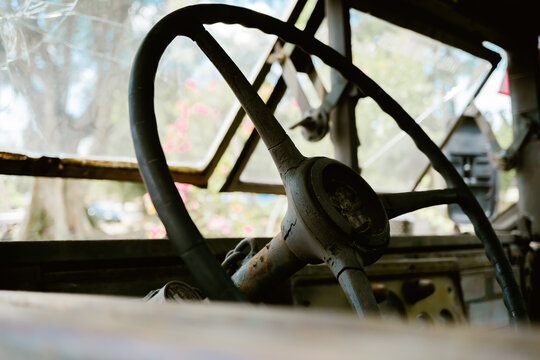 Old vintage steering wheel, rusted metal, nostalgic abandoned vehicle cabin, feeling of lonely decay, weathered texture interior