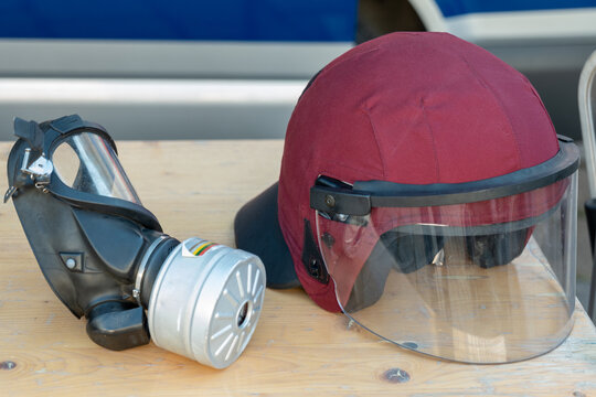 Protective respirator mask and face shield helmet on wooden table