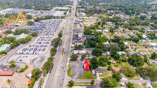 High angle drone shot of suburban neighborhood next to a highway and large parking facility with highway road drone photography urban landscape residential area city sprawl traffic flow