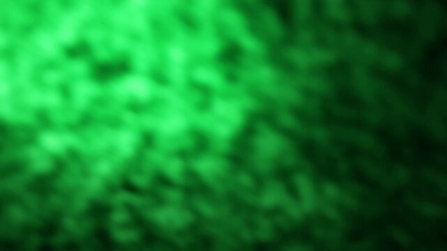 Una toma de cerca de un fondo abstracto de color verde y negro con un degradado ligero desenfocado en movimiento