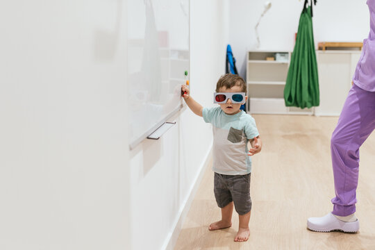 Toddler wearing 3d glasses taking eye exam with optometrist