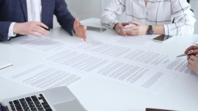 Business people discussing contract terms, outlining agreements, and reviewing legal documents during a corporate meeting, preparing for a significant partnership signing and negotiation