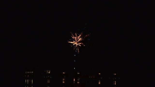 A quick volley of many fireworks in night sky.