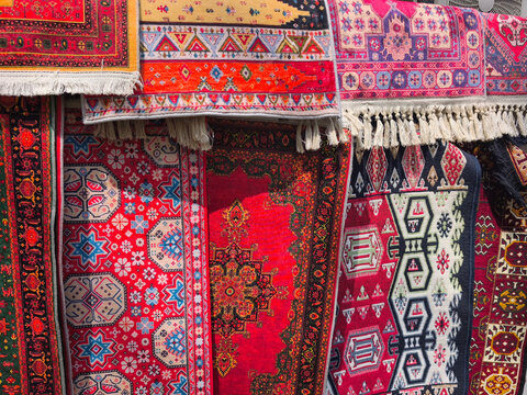 Colorful traditional handmade Azerbaijani carpets and authentic oriental rugs with intricate geometric patterns on display in Baku. Vibrant close-up shot of hand-woven wool tapestry, ornamental textil