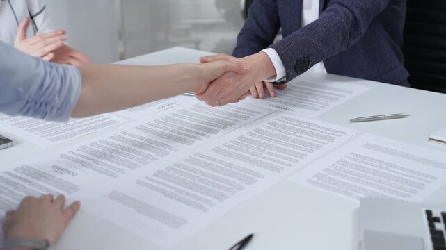 Business executives shaking hands, sealing an agreement after successful negotiations in a bright office, symbolizing partnership, collaboration, and a mutually beneficial deal signing
