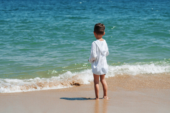 Little boy standing in the sea. Vacation at sea with children.
