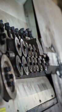 Feed rollers of a rebar bending machine pushing a steel bar at a factory