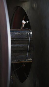 Steel wire coils spinning on a welding machine with sparks in a dark factory