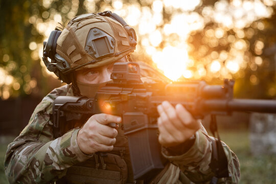 Military soldier at a position aims his assault rifle. serviceman looks through the rifle's sight while carrying out a combat mission.