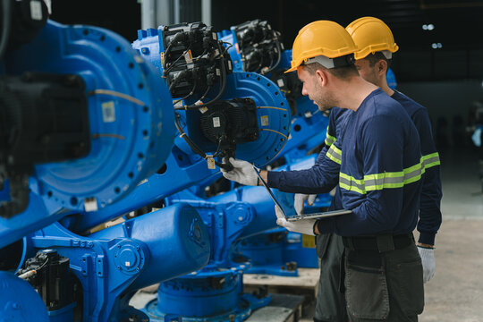 Industrial Technicians Inspect Heavy Machinery Inside A Factory.