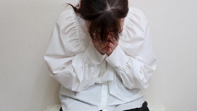 マスクをした女性　咳や頭痛の症状に苦しむ様子