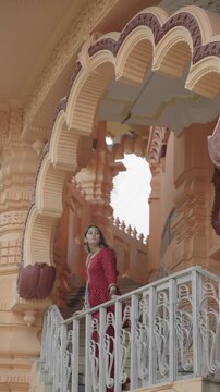 Indian woman exploring Chhatarpur Temple in Delhi while praying, walking and enjoying the temple surroundings