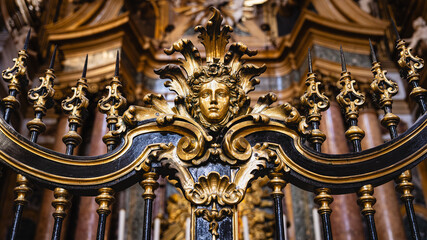 Fototapeta premium Ornate golden baroque railing with classical face sculpture