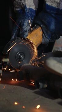 Angle grinder cutting a rusty steel pipe fitting with a shower of sparks