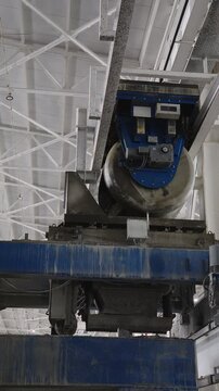 Cylindrical concrete bucket on rails tipping fresh concrete into a hopper at a concrete plant