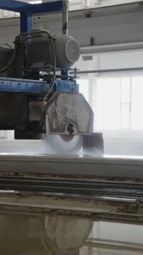 Circular saw blade cutting a concrete slab with water at a concrete plant