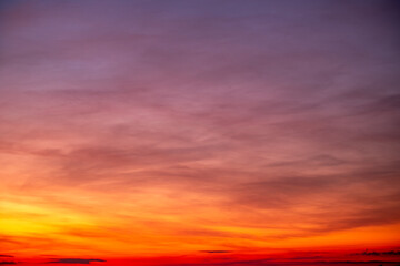 Fototapeta premium Sky sunset,Beautiful sunrise sky with vibrant gradient orange and gold colors and soft blue, Clear atmosphere with wispy clouds. Peaceful, perfect for background and copy space, High resolution images