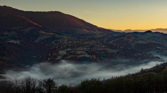 Sun rises in highland and morning fog fills valley in autumn
