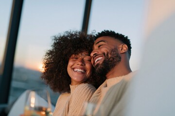 Obraz premium Smiling couple embracing on balcony at sunset with wine glasses for romantic lifestyle banner and background design