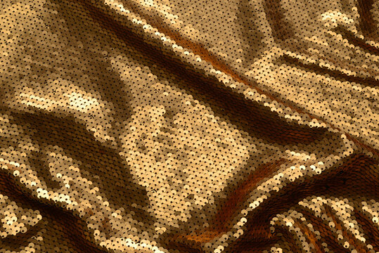 Golden sequins fabric texture. Top view.