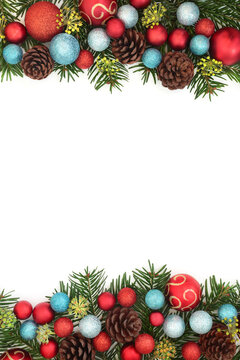 Christmas winter border of fir, natural pine cones, glittering bauble decorations on white background. Decorative Xmas festive frame design.