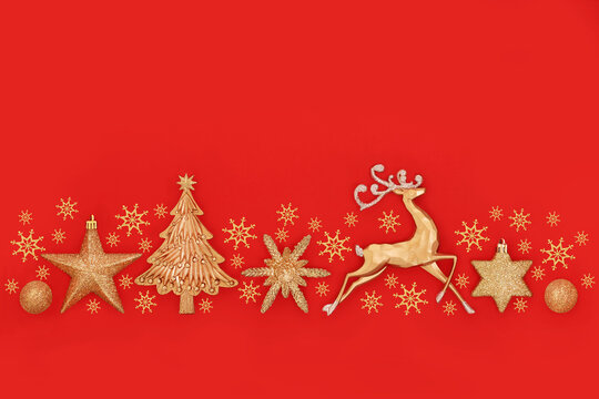 Festive gold sparkling Christmas decorations background on red. Seasonal decorative abstract banner design, with reindeer, snowflakes, tree, balls and stars.