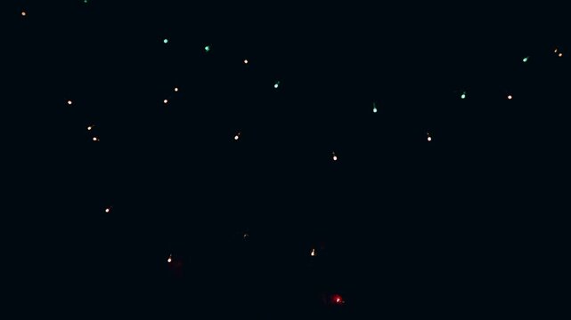 Scattered multi-colored micro LED lights shimmering subtly across a vast pitch-black background to provide a minimal starry night texture for conceptual video editing.