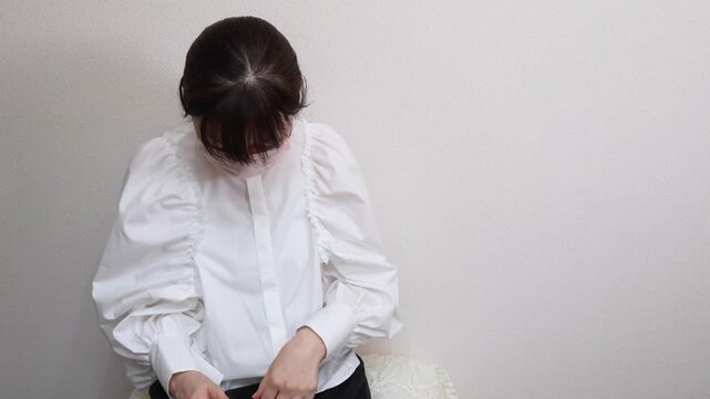 マスクをした女性　計った体温を確認した後スマートフォンを操作する女性