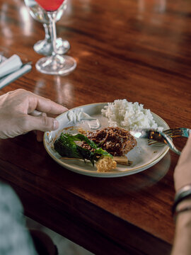 Traditional Indonesian beef rendang dish served in a plate on a restaurant table