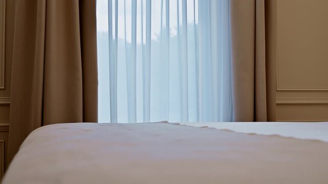 Neat bed and window with curtains in a hotel room