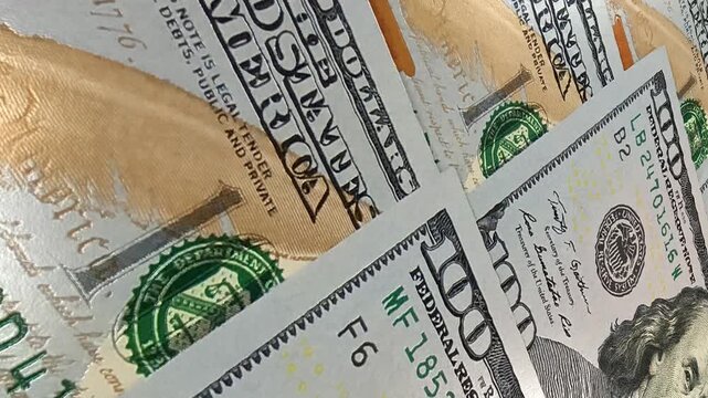 Controlled movement over detailed 100 dollar bills delivering an exclusive investment themed business background that highlights monetary wealth, financial activity, cash circulation and business grow