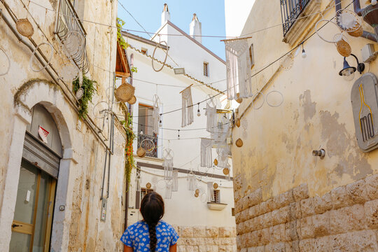 Girl exploring a decorated old town street in Puglia
