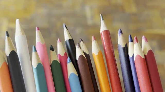 Row of multi colored wooden pencils standing together showing sharp tips. Creative drawing, school supplies, art education.