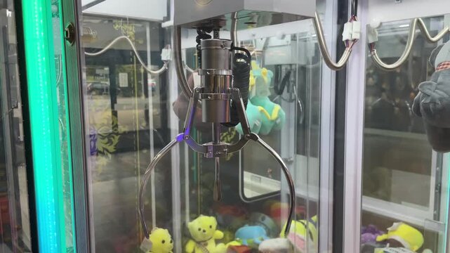 Detail of vending automat indoor. Entertainment and gaming in public leisure spaces. Closeup claw machine arcade game.