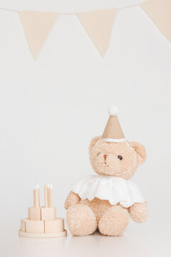 Cute plush teddy bear wearing a colorful party hat, kids birthday celebration and nursery toy decor concept