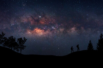 Fototapeta premium Landscape with Milky Way. Night sky with stars and silhouette of a standing happy man on the mountain, Success or winner, leader concept. High iso with Noise.