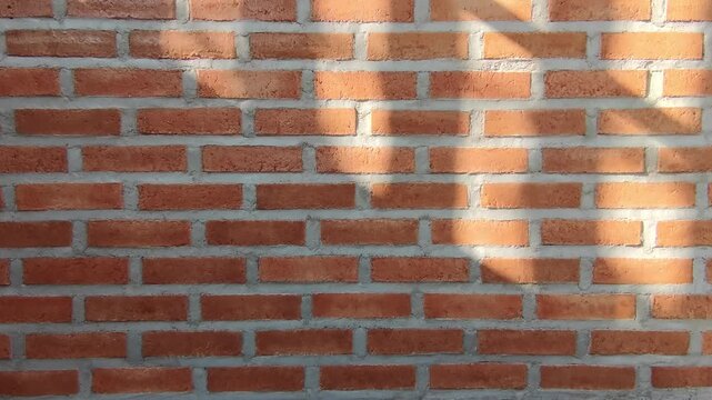 Brick wall with sunlight and shadows falling upon it background