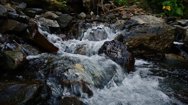 Fast flowing mountain stream rushing over rocks