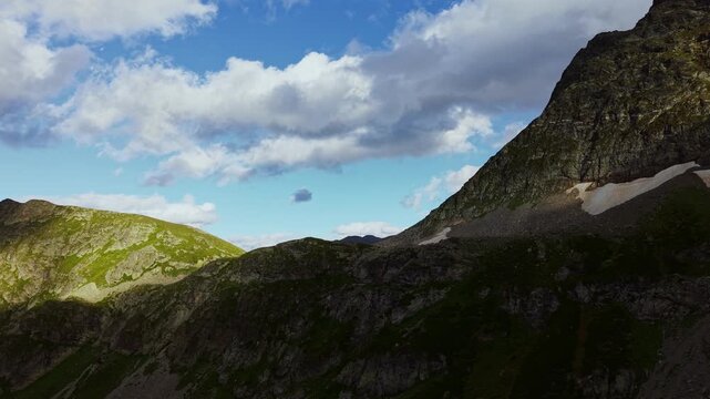 Clouds drifting over alpine mountain peaks and rocky ridges